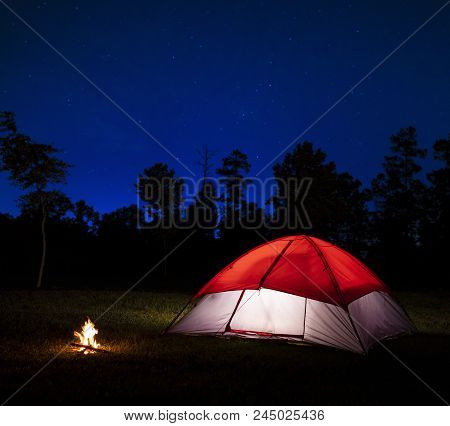 Nylon Tent With A Small Campfire At Night Under The Stars