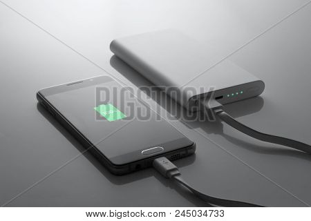 The Phone Is Charged From The Powerbank, In Dark Tones, 100% Charge