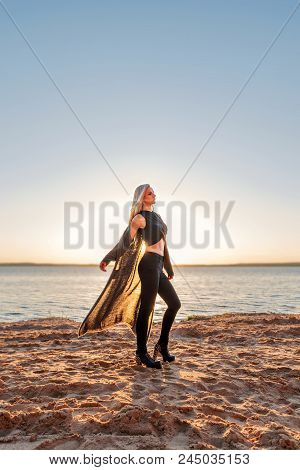 Silhouette Of A Young Sports Fitness Girl On The Coast In The Rays Of The Setting Sun