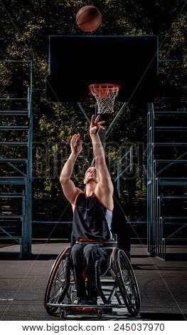 Cripple Basketball Player In A Wheelchair Plays On An Open Gaming Ground.