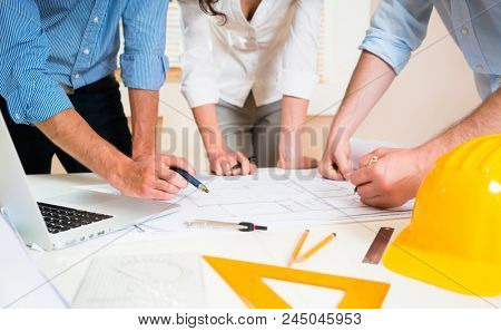 Civil engineers in discussion of construction plans for building in architect office
