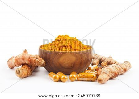 Turmeric Capsules And Turmeric Powder In Wooden Bowl On White Background. Herbal