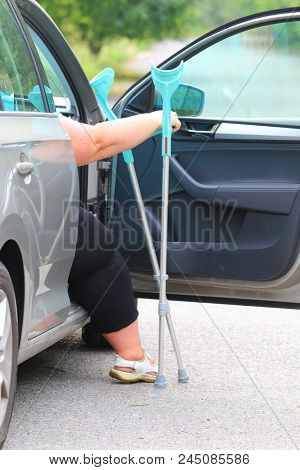 Disabled woman upgoing from a car. Transportation and travel for handicapped people.