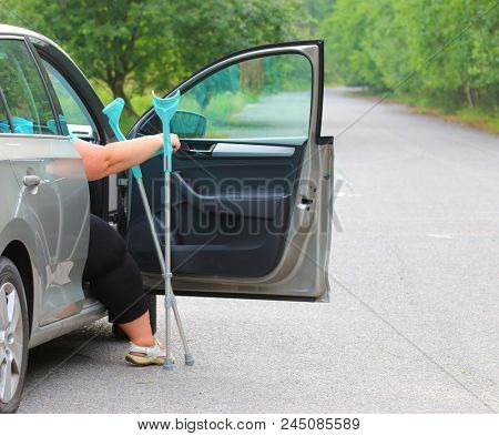 Disabled woman upgoing from a car. Transportation and travel for handicapped people.