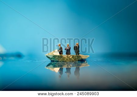 Miniature Figurine Businessmen Ride On Dollar Bill Origami Yacht