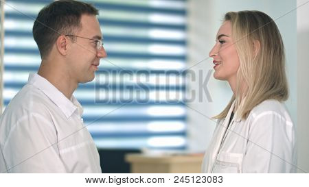 Two Friendly Female And Male Doctors Talking In The Hospital