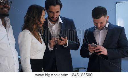 Group Of Five Multiracial Business People Standing And Using Smartphones