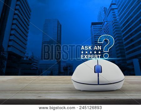 Ask An Expert With Star And Question Mark Sign Icon With Wireless Computer Mouse On Wooden Table Ove