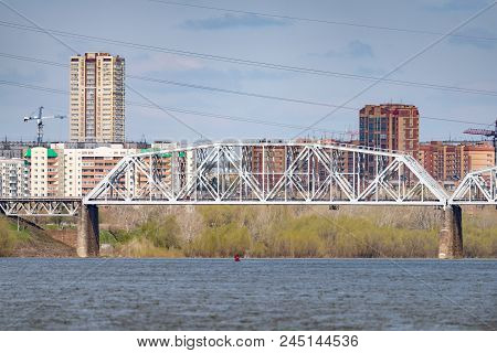 A Freight Train Is Driving Across A Bridge Across The River