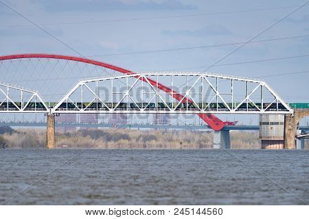 A Freight Train Is Driving Across A Bridge Across The River