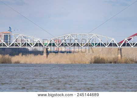 A Freight Train Is Driving Across A Bridge Across The River