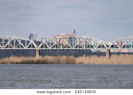 A Freight Train Is Driving Across A Bridge Across The River