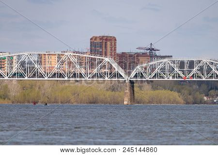 A Freight Train Is Driving Across A Bridge Across The River
