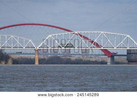 The Train Travels Along The Railway Bridge Across The River