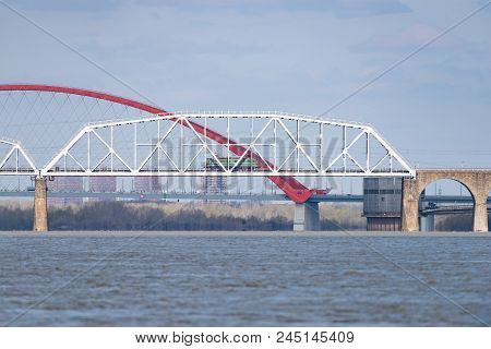 The Train Travels Along The Railway Bridge Across The River