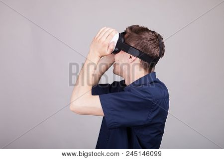 Excited Man Experiencing Virtual Reality For The Firts Time. He Is Wearing A Vr Headset. Gray Backgr