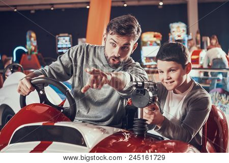 Joyfull Father And Son Sitting On Toy Car. Spending Holiday Together With Family. Entertainment Cent
