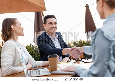 Well-qualified Manager. Well-qualified Promising Manager Feeling Excited While Shaking Hand Of His A