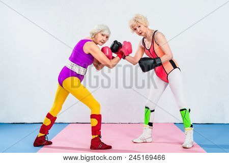 Full Length View Of Senior Sportswomen In Boxing Gloves Training And Looking At Camera