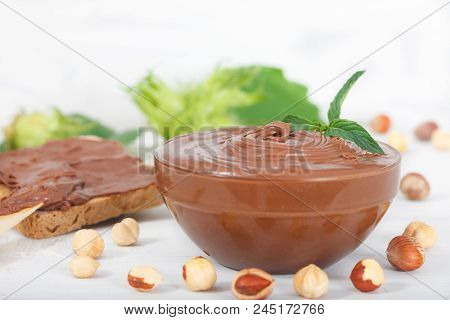 Homemade Hazelnut Spread In Glass Bowl. Hazelnut Nougat Cream On Slice Of Bread For Breakfast.