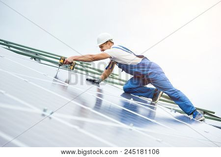 Construction Worker Connects Photo Voltaic Panel To Solar System Using Screwdriver. Professional Ins