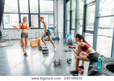 Three Smiling Multicultural Sportswomen Exercising At Gym
