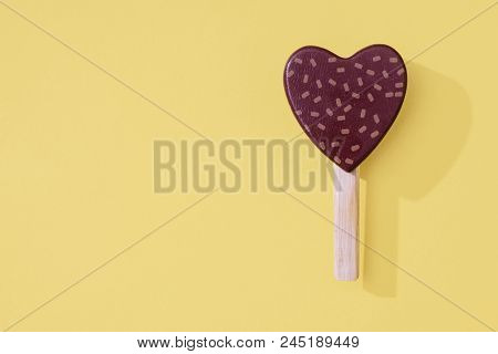 Heart Shaped Ice Cream Popsicle Lollipop On A Pastel Yellow Background For Summer Or Valentines Day.