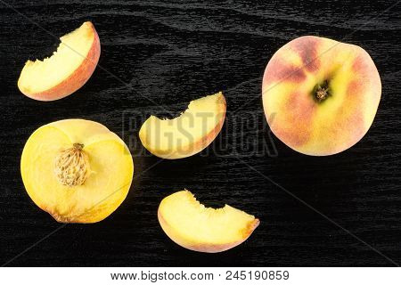 One Yellow Peach, A Section Half And Three Slices, Flatlay, On Black Wood Background