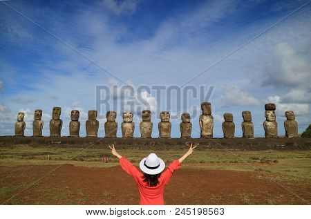 One Female Raising Her Arms Happily In Front Of Moai Statues Of Ahu Tongariki On Easter Island, Chil