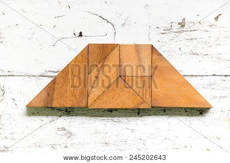 Tangram Puzzle In Trapezoid Or Trapezium Shape On Old White Wood Background