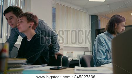 Young Team Leader Is Consulting The Emploees And Discussing The Project In The Office With Computers
