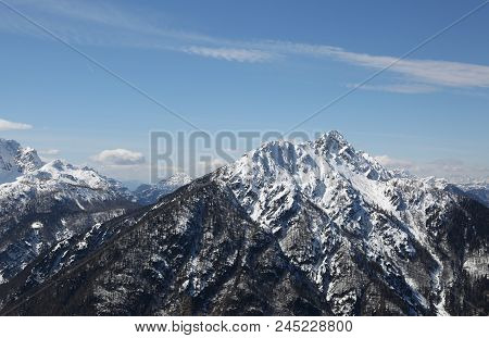 Panoramic View Of Mountains In Winter And Some White Clouds On The Sky