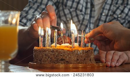 Two Hand Lighting Candles In Birthday Cake. Professional Shot In
