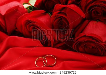 Bouquet Of Red Roses With Golden Rings On Satin