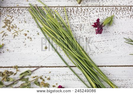 Tarragon, Rosemary, Chives, Sage, Marjoram And Dill Herbs On A Rustic Table Top With Edible Flowers