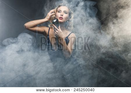 Sexy Young Girl Singer Singing With Silver Retro Microphone On Black Background