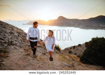 Romantic Summer Love Story On A Sunset In Mountains. Young Girl And Boy In Love.