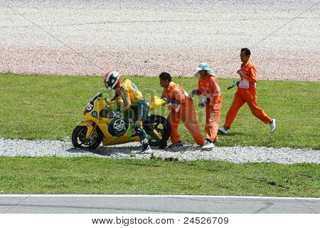 SEPANG, Malajsie - 21. října: Maršálové pomáhat Moto2 jezdec Mattia Pasini, poté, co havaroval na fre
