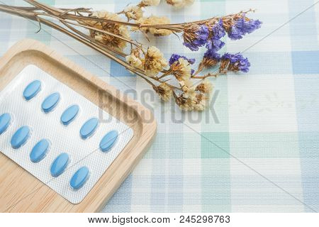 Blue Blister Pack Of Medical Pills On Wood Plate.