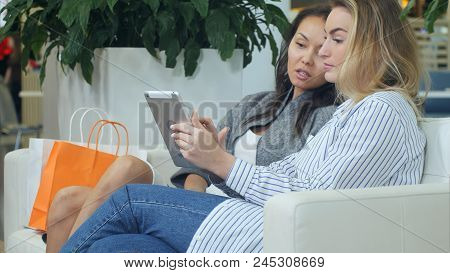 Two Female Friends Having Fun While Shopping In A Mall