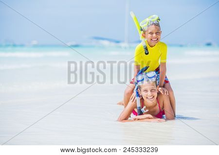 Brother And Sister Playing And Having Fun On The Beach During The Hot Summer Vacation Day.