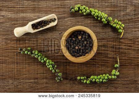 Unripe Drupes Of Fresh Black Pepper Flatlay On Brown Wood Backgound Four Bunches One Wooden Bowl And