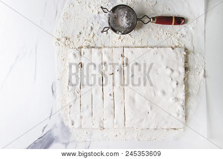 Homemade Honey Nuts Nougat Turron Sliced On Crumpled Paper With Vintage Sieve And Sugar Powder Over 