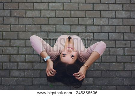 Young Smiling Teen Girl Looking At Camera. Shot From Above.