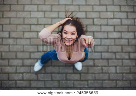 Young Smiling Teen Girl Looking At Camera. Shot From Above.