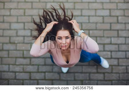 Young Smiling Teen Girl Looking At Camera. Shot From Above.