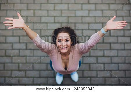 Young Smiling Teen Girl Looking At Camera. Shot From Above.