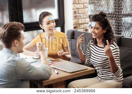 Social Interaction. Joyful Young People Having Fun While Playing A Game In The Cafe