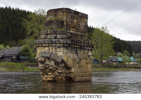 Support Of An Ancient River Bridge Destroyed By An Ice Break Across The River In The Village