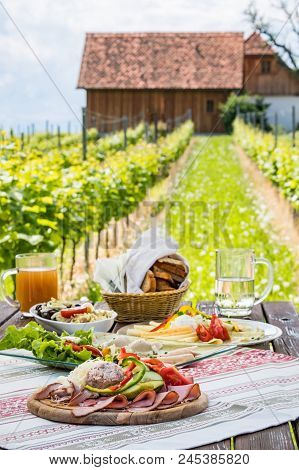 Brettljause, Traditional Cold Plate With Meat, Cheese, Fish, Vegetable, Bread And Drinks On Wooden T